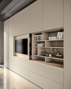 an entertainment center with built in shelving and bookshelves on each side, along with a flat screen tv