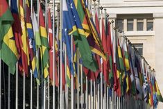 many flags are lined up in front of a building