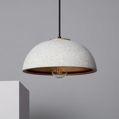 a white light hanging from a ceiling fixture