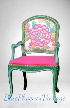 a green chair with a pink cushion on it's arm and back, sitting in front of a white background