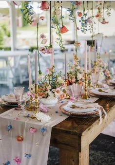 the table is set with flowers and candles for an elegant dinner or party setting in pastel colors