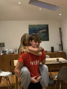 two people hugging each other in the living room