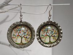 the earrings are decorated with colorful tree designs