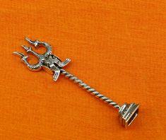 a silver metal key on an orange background