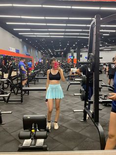 a woman taking a photo of herself in the gym