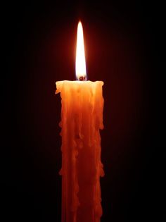 an orange candle lit up in the dark