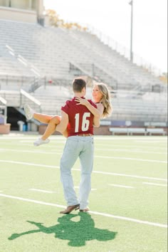 a man carrying a woman on his back while standing on top of a football field