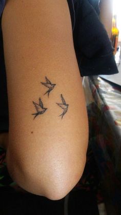 a woman's arm with three birds on it