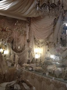 a room filled with lots of white furniture and chandeliers