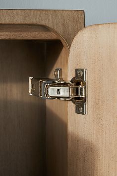 a wooden cabinet with a metal latch on the front and side doors open to reveal a light wood finish