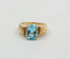 14K yellow gold blue topaz oval faceted stone measuring 8 x 10 mm, Circa 1990, Shank is set with diagonal raised panel with florentine finish, ring size 5, weight 3.5 grams. Stock # BRT2061 Most rings are sizable for a small fee. If the ring you are considering is the incorrect size contact us for a quote. This listing contains photographs of the actual item you will receive. Our items are in excellent condition with little or no signs of wear and many are one of a kind pre-owned estate finds. P Antique Oval Topaz Ring In 14k Gold, Gold Oval Cabochon Topaz Ring Gift, Oval Blue Topaz Yellow Gold Jewelry, Blue Oval Cabochon Topaz Ring Gift, Blue Turquoise 14k Gold Oval Cabochon Ring, Blue Band, Fine Jewelry Designers, Anniversary Bands, Blue Topaz Ring