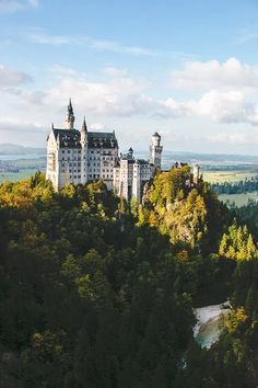 a castle on top of a hill surrounded by trees