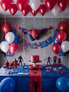 a spiderman birthday party with balloons and decorations on the table, along with toys