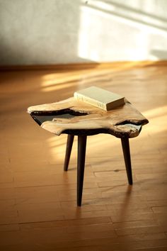 a wooden table with a book on it in the middle of a wood floored room