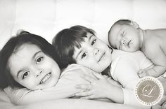 three young children laying on top of each other in black and white with the letter c above them