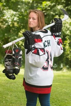 a woman holding a hockey stick and glove