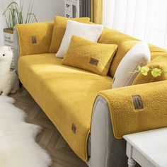 a living room with yellow couches and white rugs