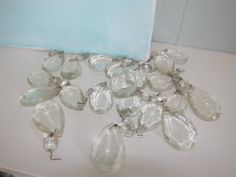 a bunch of clear glass beads hanging from a hook on a white counter top next to a blue towel