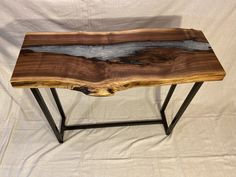 a wooden table with metal legs on a white background