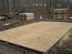 some wood pallets in the middle of a wooded area with trees and woods behind them