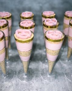 several cones with pink frosting and gold rims