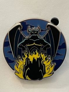 a blue and yellow plate with an image of a demon sitting on top of it