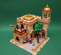 a model of a building with a gold dome and palm tree in front of it