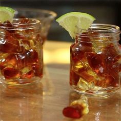 two jars filled with jelly and lime on top of a table