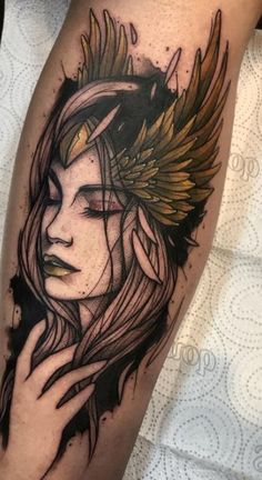 a woman's face with wings on her head and arm, done by tattoo artist person