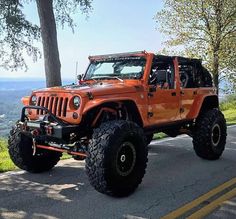 an orange jeep parked on the side of a road