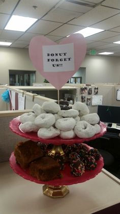 three tiered trays filled with donuts on top of a desk in an office