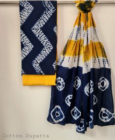 two scarves hanging on the wall next to each other, one is blue and yellow