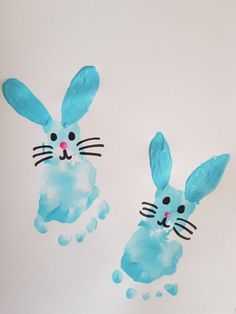 two handprinted blue rabbits on white paper