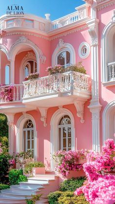 a pink house with white balconies and flowers