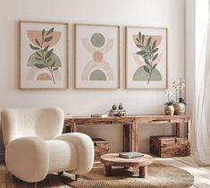 three paintings hang on the wall above a chair and coffee table in a living room