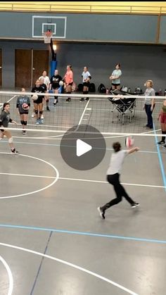 a group of people on a basketball court playing with a frisbee in the air