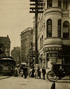 an old black and white photo of people walking down the street