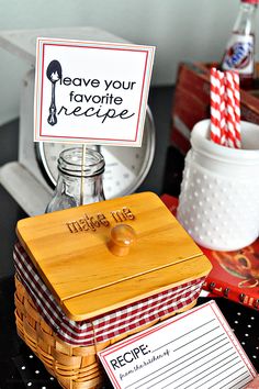 a table topped with boxes filled with food and drinks next to a sign that says leave your favorite recipe