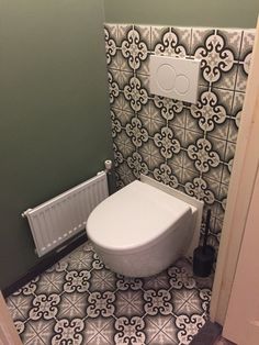 a white toilet sitting inside of a bathroom next to a radiator and wall