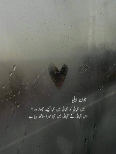 rain drops on the window with an arabic message written in english and two hearts are visible