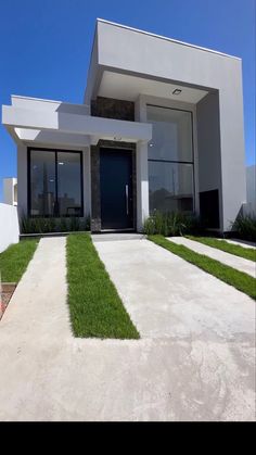 a modern house with grass in the front yard