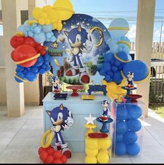 balloon decorations and balloons are on display in front of a table with sonic the hedge theme