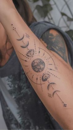 a man's arm with phases of the moon and stars on it