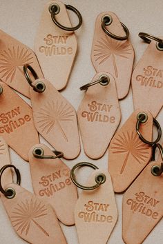 several leather key chains with stay wild tags attached to them