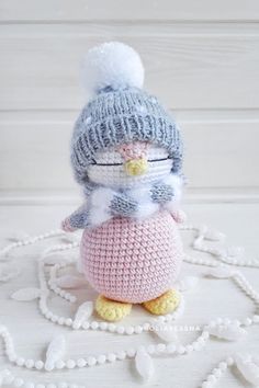 a crocheted penguin doll sitting on top of a ball