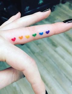 a woman's finger with hearts painted on it