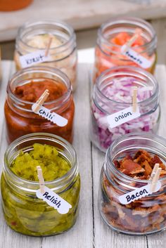 several jars filled with different types of food and labeled with labels on them sitting on a table