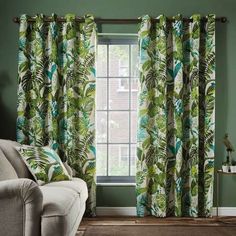 a living room with green walls and curtains