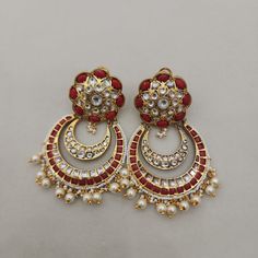 Add a touch of elegance to your look with our Flower Coral Chandbali Earrings. Featuring kundan designs with coral stones, these chandbalis are perfect for enhancing your bridal or festive attire. Their intricate craftsmanship and rich color make them a standout choice for those seeking a blend of tradition and style. Ideal for special occasions, these earrings promise to bring a touch of grace to any outfit. Length: 3" to 3.5" Material: 24Kt gold foil, lac Stones: Kundans, semi precious corals, Ceremonial Multicolor Chandbali Earrings, Luxury Traditional Jewelry With Red Coral, Luxury Traditional Red Coral Jewelry, Luxury Multi-stone Chandbali Earrings, Traditional Hand-strung Red Coral Beads, Festive Attire, Chandbali Earrings, Coral Stone, Pin Pendant