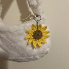 a stuffed animal with a crocheted sunflower on it's back hanging from a key chain